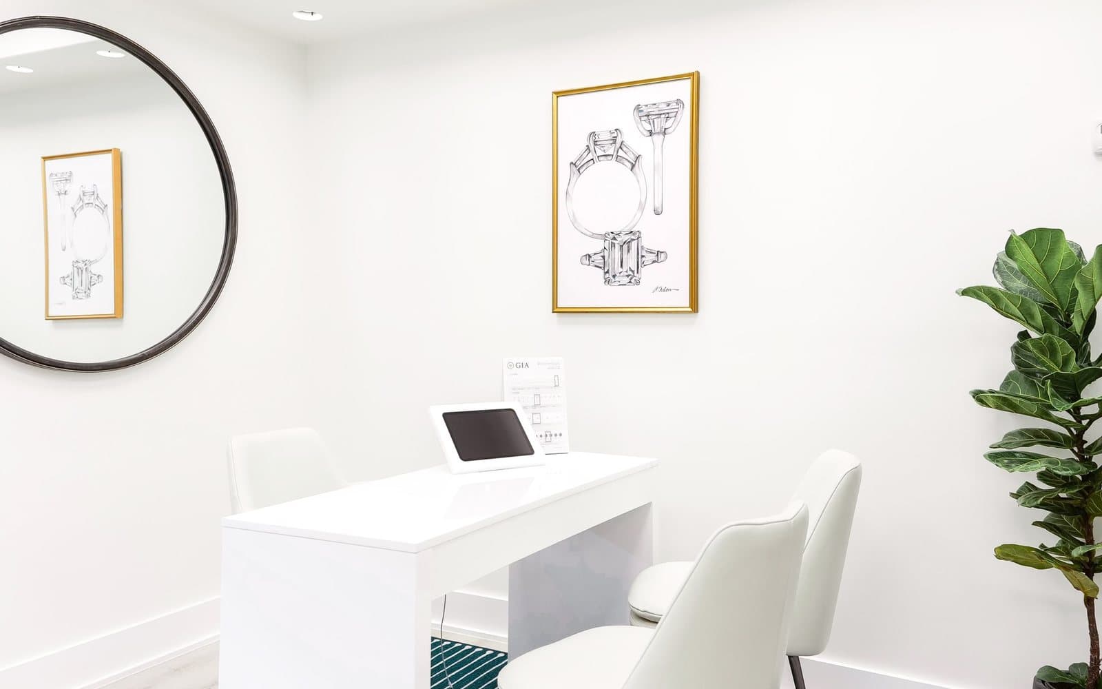 A private Buchroeders consultation room with a tablet on a stand and a printed GIA diamond grading report on a white desk beside two chairs